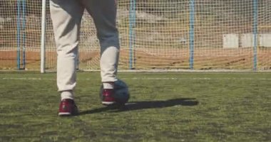 Futbolcu topla kaleye koşar ve gol atar. Sinematik kamera görüntüsü