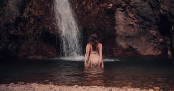 Молодая Девушка Входит Воду Останавливается Перед Водопадом Поднимает Руки Вверх — стоковое видео
