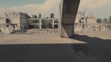 Bir İHA, terk edilmiş bir binanın içinde sağdan sola uçuyor ve başka bir İHA 'nın uçağını yakalıyor.