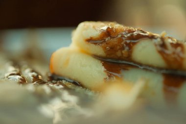 Üstünde çikolata sosu olan bir parça krep. Krep iki parçaya bölünür ve bir tabağa oturur..