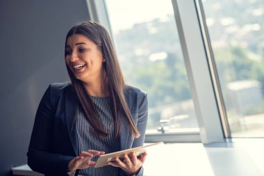 Genç çekici kadın Yöneticisi duran modern Office dijital tablet üzerinde çalışan.