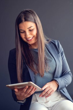 Genç çekici kadın Yöneticisi duran modern Office dijital tablet üzerinde çalışan.