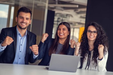 İş ekibi dizüstü bilgisayar kullanarak proje üzerinde işbirliği yapıyor. Güncel ofis ortamında sıradan iş arkadaşları birlikte çalışıyor. Takım çalışması konsepti