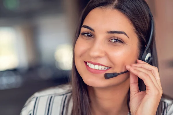 stock image Young friendly operator woman agent with headsets working in a call centre
