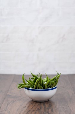 Mutfak tezgahında bir kase yeşil fasulye.