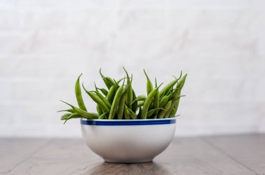 Mutfak tezgahında bir kase yeşil fasulye.