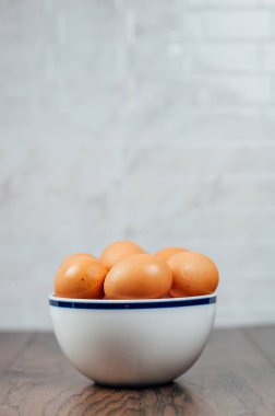 Mutfak tezgahında bir kase çiğ kahverengi yumurta