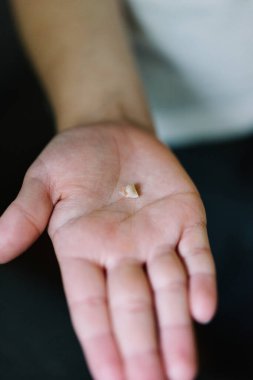 Kayıp bir bebek dişini tutan bir çocuğun elini kapat.