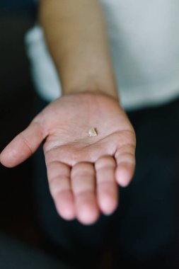 Kayıp bir bebek dişini tutan bir çocuğun elini kapat.