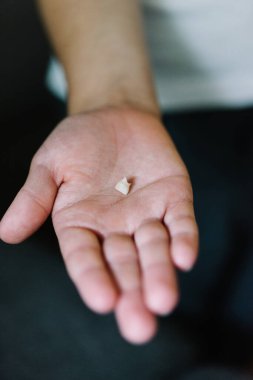 Kayıp bir bebek dişini tutan bir çocuğun elini kapat.