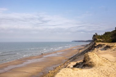 Dalgaları ve kumlu kumlu kumlu güzel mavi deniz. Sazlıklar ve kumullar arasında kuru çimenler. Yaz ve tatil kavramlarında seyahat.