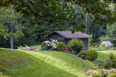 Çeşit çeşit çiçek ve çalı bahçeleri olan güzel bir bahçe. İyi bakımlı peyzaj, renkli ve davetkar bir alan yaratır. Bahçe, ev ya da doğa projeleri için mükemmel..