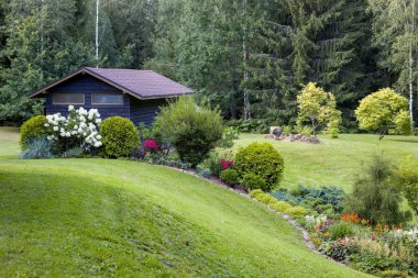 Çeşit çeşit çiçek ve çalı bahçeleri olan güzel bir bahçe. İyi bakımlı peyzaj, renkli ve davetkar bir alan yaratır. Bahçe, ev ya da doğa projeleri için mükemmel..