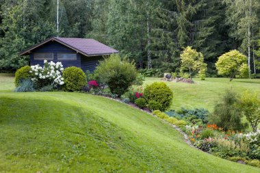 Çeşit çeşit çiçek ve çalı bahçeleri olan güzel bir bahçe. İyi bakımlı peyzaj, renkli ve davetkar bir alan yaratır. Bahçe, ev ya da doğa projeleri için mükemmel..