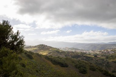 Engebeli dağ manzarası Bandama Caldera, Gran Canaria, kayalık ya da çıkıntılı. Açık mavi gökyüzü ve seyrek bitki örtüsü.