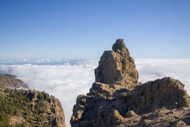 Pico de las Nieves, Gran Canaria 'nın en yüksek zirvesi, bulutlar denizi üzerinde. Sersemletici bir dağ manzarası berrak mavi gökyüzü.