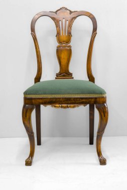 Bu sandalye ahşap bir çerçeve ve zengin yeşil bir yastıkla karmaşık bir işçilik sergiliyor. Klasik iç dekorasyon için mükemmel bir şekilde tasarlanmış, zarafetiyle her yeri güzelleştiriyor..