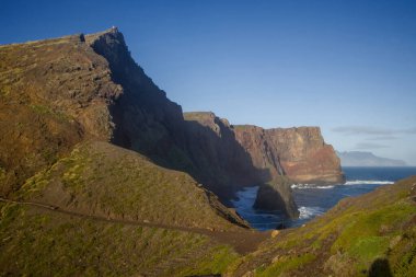 Madeira 'daki Ponta de Sao Lourenco' da Atlantik Okyanusu 'nun üzerindeki engebeli uçurum kulesi. Güneş ışıl ışıl parlıyor, canlı manzarayı aydınlatıyor ve eşsiz jeolojik oluşumları vurguluyor..