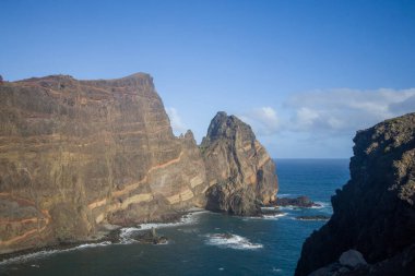 Majestic kayalıkları Madeira 'daki Ponta de Sao Lourenco' da Atlantik Okyanusu 'ndan keskin bir şekilde yükselir. Engebeli manzara, parlak mavi gökyüzünün altındaki bölgenin doğal güzelliğini vurguluyor..