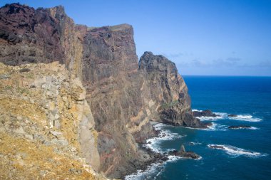 Madeira Ponta de Sao Lourenco 'da okyanustan nefes kesen uçurumlar keskin bir şekilde yükselir. Dalgalar açık mavi gökyüzünün altında kayalık kıyılara çarpar ve doğal güzellikleri gösterir..