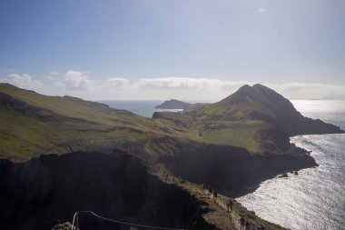 Ziyaretçiler, Ponta de Sao Lourenco 'nun engebeli patikaları boyunca yürüyüp, açık bir günde Madeira' nın nefes kesici kıyı manzarasını ve eşsiz kaya oluşumlarını izliyorlar..