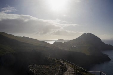 Bir yürüyüşçü, Madeira 'daki Ponta de Sao Lourenco' da dolambaçlı bir yolda yürüyor. Etrafı nefes kesen uçurumlar ve parlak bir gökyüzünün altında ışıldayan Atlantik Okyanusu ile çevrili..