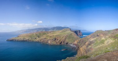 Madeira 'daki Ponta de Sao Lourenco' daki engebeli kayalıkların ve masmavi suların nefes kesici manzarası. Yeşillik, kayalık araziyle çelişiyor. Resimli bir sahil manzarası yaratıyor..