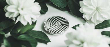 Kolaj, geometrik şekiller ve çiçekler arasında dekoratif kompakt bir aynanın yakın çekimini içerir..