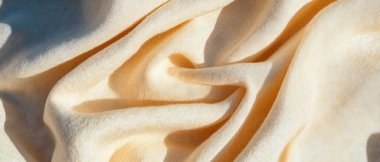 Boş yumuşak bej kumaş dokusu çeşitli kullanım alanları için sıcak, davetkar ve çok yönlü bir zemin oluşturur..