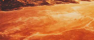 Güneş sakin suların üzerinde batarken ılık turuncu renkler gökyüzünü dolduruyor ve huzurlu bir ortam yaratıyor..