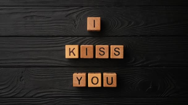 Stop Motion Wooden Cubes Phrase Kiss You Black Background Wooden — 图库视频影像