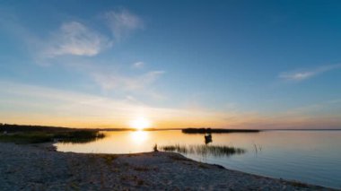 Ukrayna 'da Svityaz Gölü' nün balıkçı tekneleriyle kumsalda bulutlarla gün batımının zamanı..