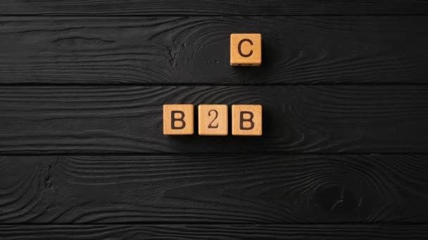 木制立方体与字母和短语B2B移动并改变为黑色背景的B2C 停止运动 循环视频 高质量的4K镜头 — 图库视频影像