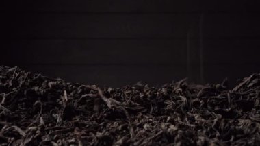 Siyah büyük yaprak çayı bir yığın içine dökülür. Yakın plan, kenar görünüm