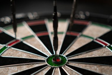 Üç ok dart tahtasına isabet etti. Şanslıyız. Dartlardan biri hedefi vurdu. Kazanma ve şans kavramı. Yakın çekim, açılı görünüm