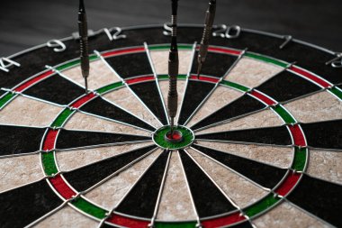 Üç ok dart tahtasına isabet etti. Şanslıyız. Dartlardan biri hedefi vurdu. Kazanma ve şans kavramı. Yakın çekim, açılı görünüm