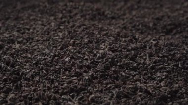 Siyah yelpaze ya da kırık yaprak çayı bir yığın içine dökülür. Yakın plan, kenar görünüm