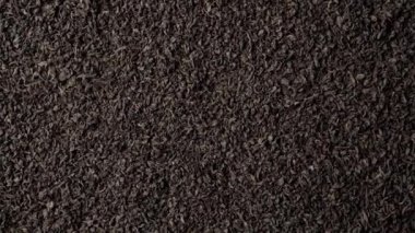 Siyah yelpaze ya da kırık yaprak çayının arka planı yavaşça dönüyor. Kapat, üst görünüm