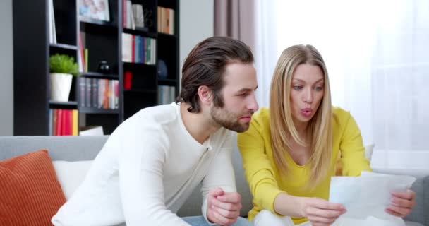 백인젊은 아내와 남편은 집에서 소파에 동안많은 스트레스를 남녀는 서류를 확인하고 — 비디오
