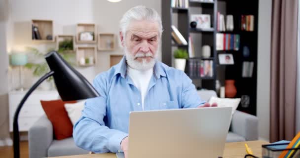 白种人灰白头发的男性作家在家里用笔记本电脑键盘发短信 编故事 退休老人在客厅里写书和打字 Hobby 自由职业 — 图库视频影像