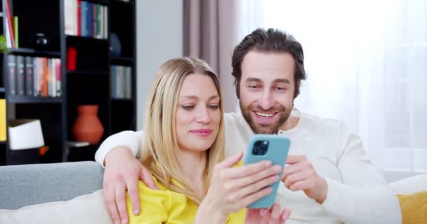 Χαρούμενη Καυκάσια Σύζυγος Και Σύζυγος Κάθονται Στον Καναπέ Στο Άνετο — Αρχείο Βίντεο