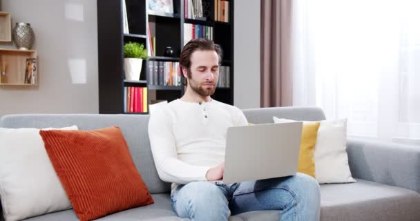 Pria Yang Bosan Fokus Mengetik Laptop Duduk Sofa Ruang Tamu — Stok Video