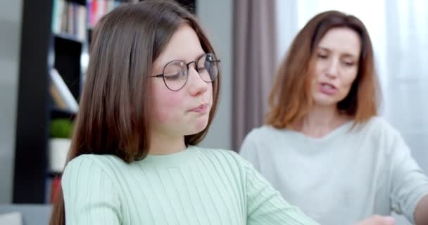 怒っている悲しい娘と患者の母親は宿題をしています 母は十代の少女に運動を説明する 困難な宿題を学ぶ勉強不安の女の子を動揺 疲れた学生が頭に触れる 宿題のコンセプト — ストック動画