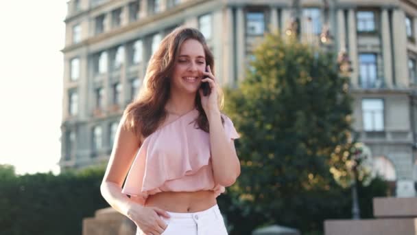 야외에서 스마트폰을 매력적 여자의 초상화 아름다운 코카서스 소녀가 거리에서 전화를 — 비디오