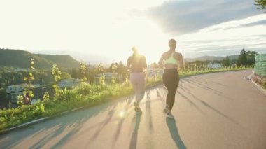 Sokakta koşan genç atlet kadınlar, çok antrenman yapıyorlar, yarış ya da maratona hazırlanıyorlar. Sağlıklı koşu ve açık hava egzersizi kavramı.