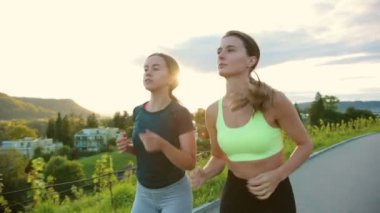 Sokakta koşan genç atlet kadınlar, çok antrenman yapıyorlar, yarış ya da maratona hazırlanıyorlar. Sağlıklı koşu ve açık hava egzersizi kavramı.