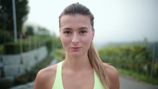 若い美しい白人女性の肖像画は カメラと笑顔を見て 訓練後に満足している 健康的なライフスタイルのためのスポーツ演習の概念 — ストック動画