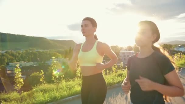 白人のかなり若い女性が道路をジョギングし 一緒に働く 女性の友人が一緒に訓練 スポーツライフスタイルコンセプト — ストック動画