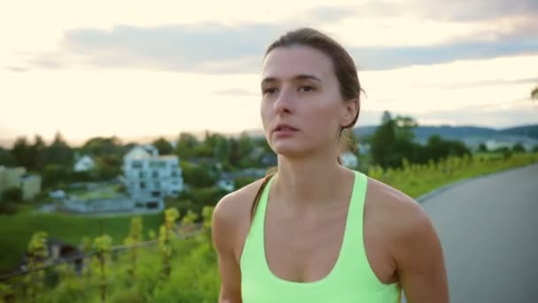 ストリートを走っている若いアスリートの女性の肖像画 ハードトレーニング レースの競争やマラソンの準備を取得 健康的なランニングと屋外運動の概念 — ストック動画