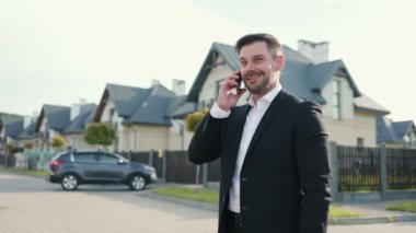 Kafkas asıllı profesyonel bir erkeğin portresi şehirde duruyor ve akıllı telefondan konuşuyor. Yakışıklı bir iş adamı sokakta cep telefonuyla konuşuyor. İş konsepti